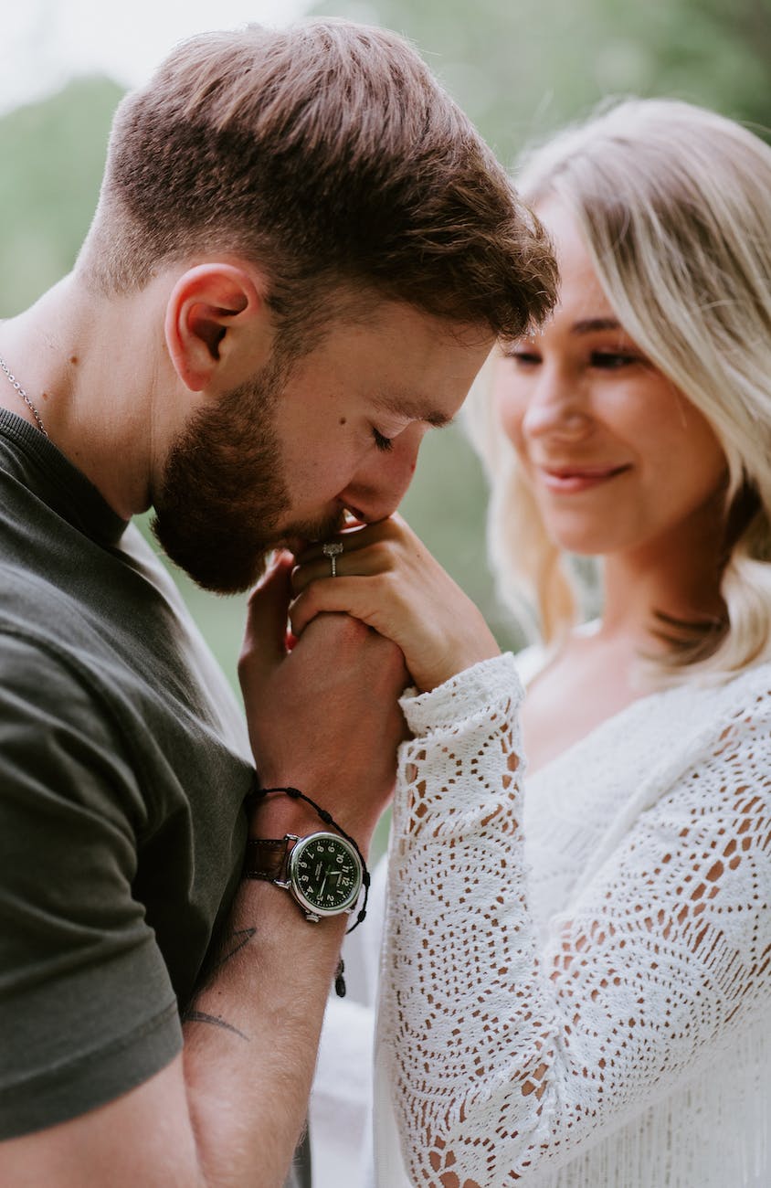 man kissing his fiancees hand