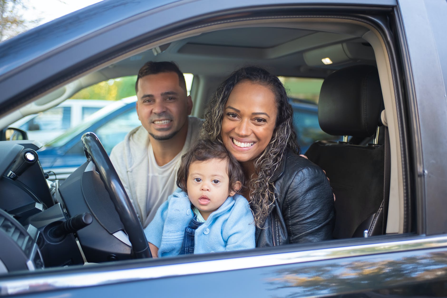 parents inside a car with their child